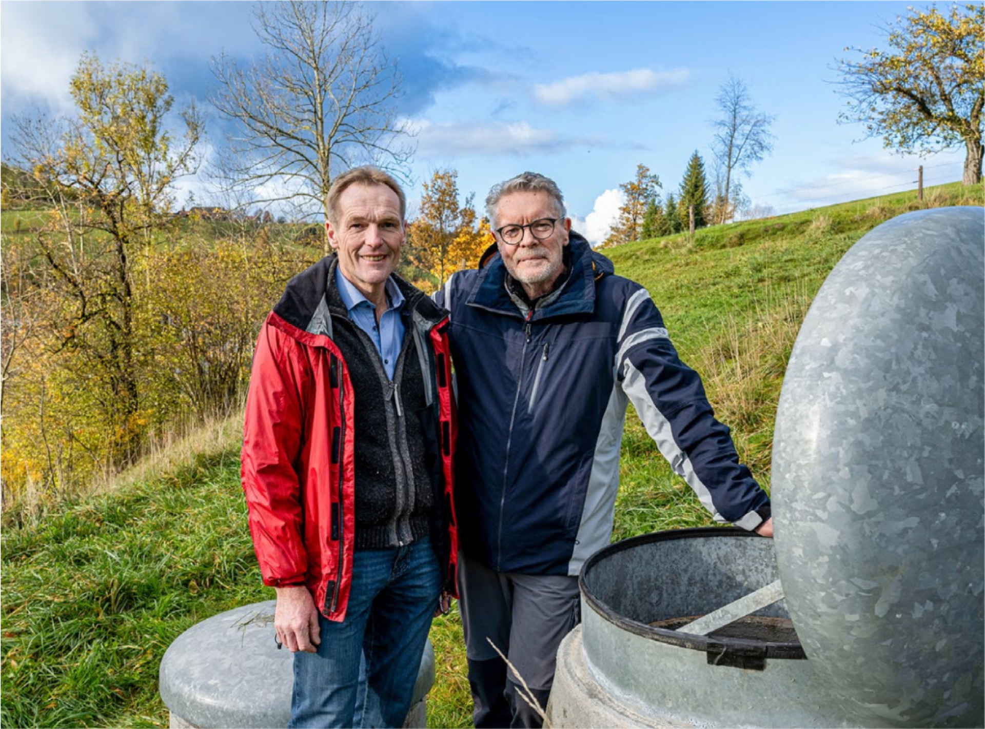 Landwirt Hans Peter-Suppliger (links) und Tüftler Roland Christen neben der Quellfassung, in der künftig der Kohlefilter das Trinkwasser reinigen wird. BILD: ZVG / LUKAS ZIEGLER, SCHWEIZER BERGHILFE