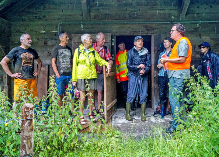 Unter dem schützenden Dach folgen die ExkursionsteilnehmerInnen den Ausführungen des Experten Christoph Käsermann (mit Leuchtweste). BILD: SONJA STEUDLER