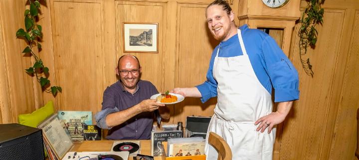 DJ Ernio dell Disco erhält von Matthias von Känel eine Portion Risotto direkt an seinen Arbeitsplatz geliefert. BILD: MICHAEL SCHINNERLING