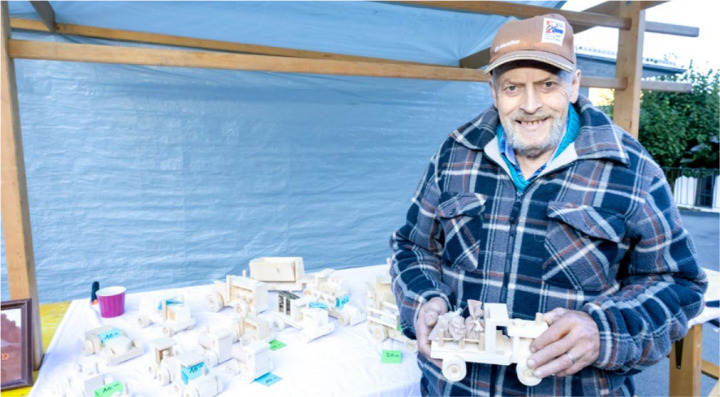 Bruno Walthert pries seine handwerklichen Produkte wie Lastwagen und Eisenbahnen aus Holz an.