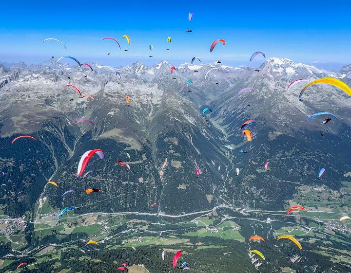 Farbenpracht am Sommerhimmel – die Gleitschirmflieger im Schwarm über Disentis
