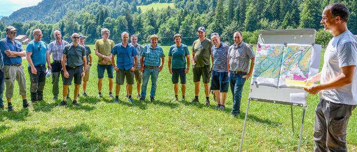 Förster Jonas Heuberger (rechts) erklärt in Unterseen den Anwesenden unter anderem die Schutzfunktion des Waldes am Beispiel des Chienbergwalds (im Hintergrund). BILDER: HANS HEIMANN