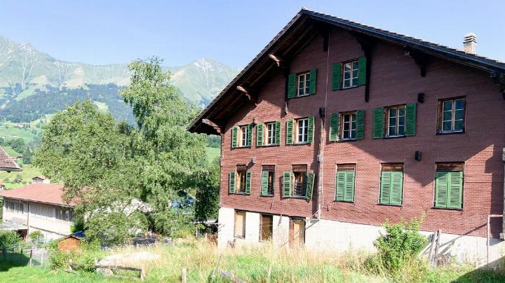 Das alte Schulhaus Hasli soll künftig zonenkonform bewohnt werden dürfen – links unten im Bild das neue Schulhaus. BILD: HSF
