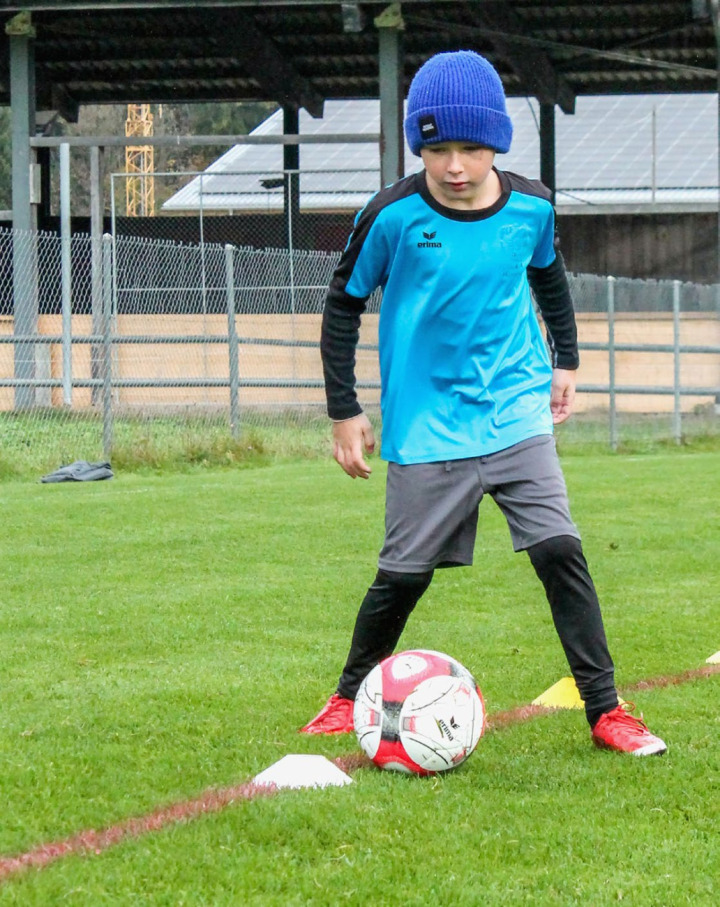 Ein Nachwuchsfussballer übt den Slalomlauf mit Ball. BILD: PETER SCHMID